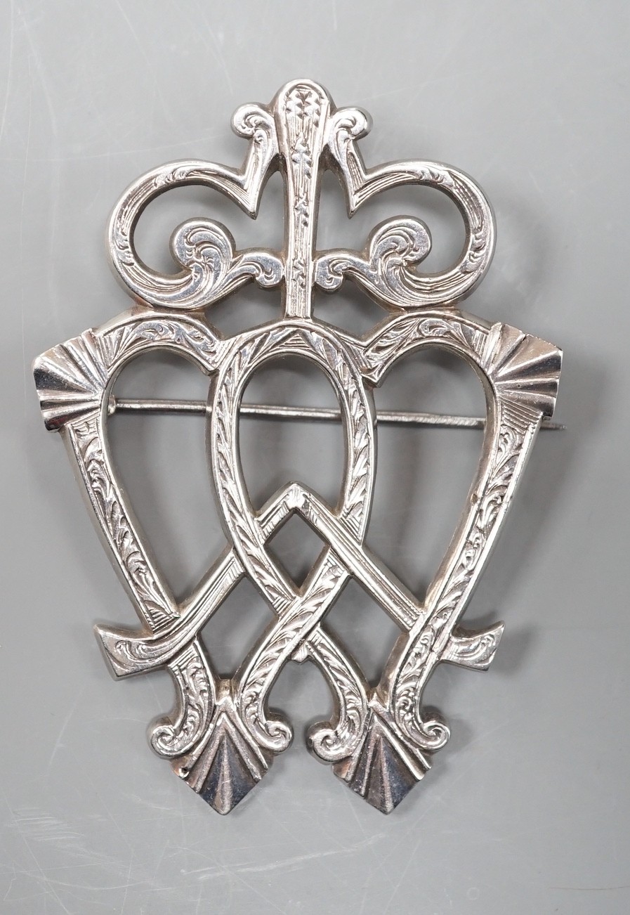 A white metal entwined twin heart brooch, with scrolling terminal, unmarked, 70mm.